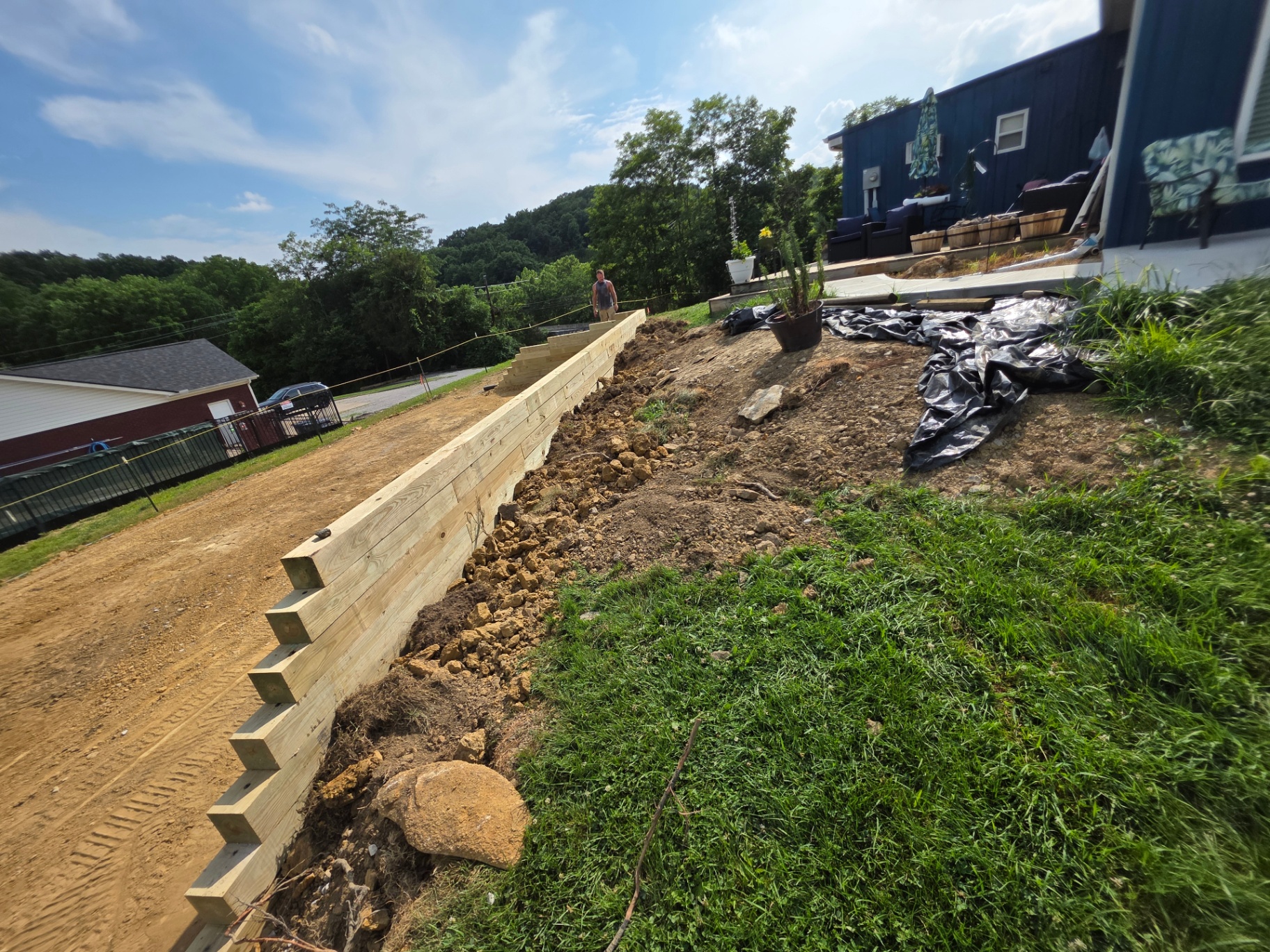Timber retaining wall construction in progress along a driveway in Northern Kentucky