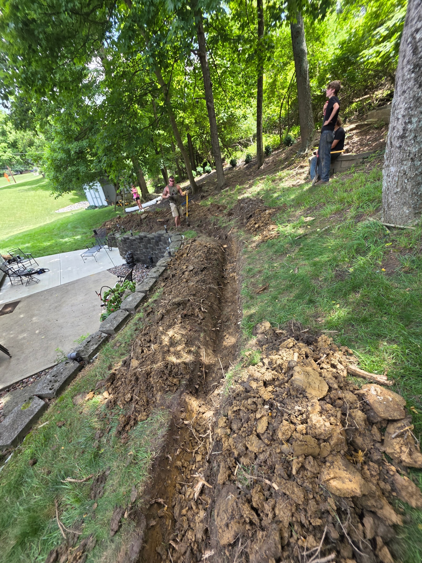 Hillside drainage trench dug behind retaining wall in Northern Kentucky by MX Property Services
